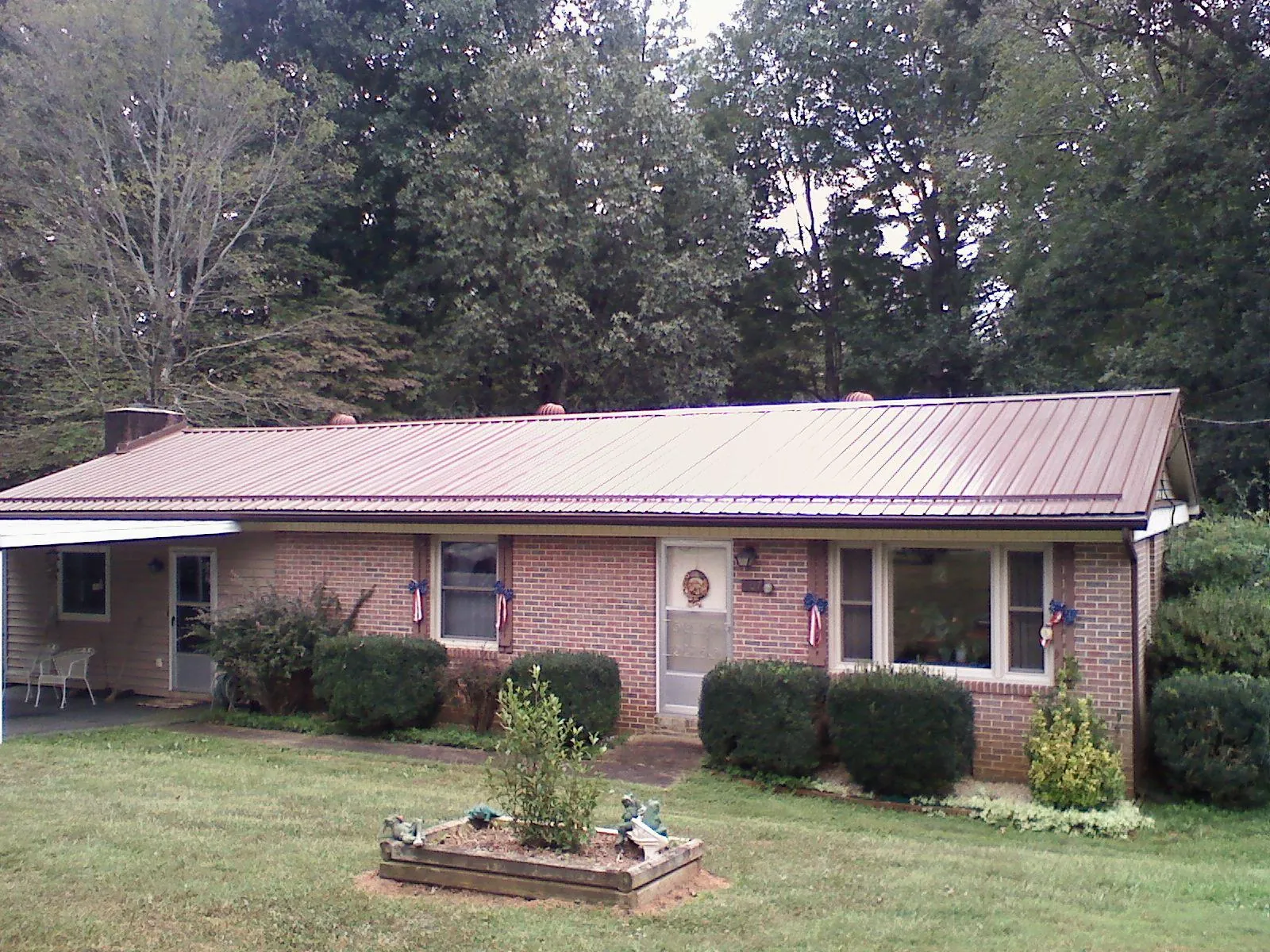 Bronze metal roof on a brick ranch home with a carport in Port Tobacco