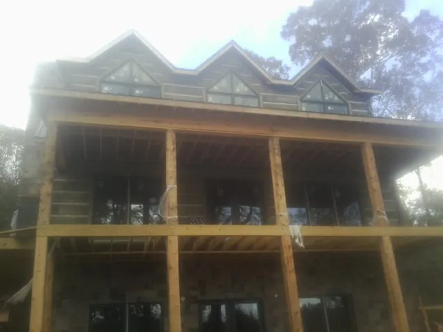 Dormers and porch framing on a large log home under construction — Roof Coating work by our crew in Port Tobacco