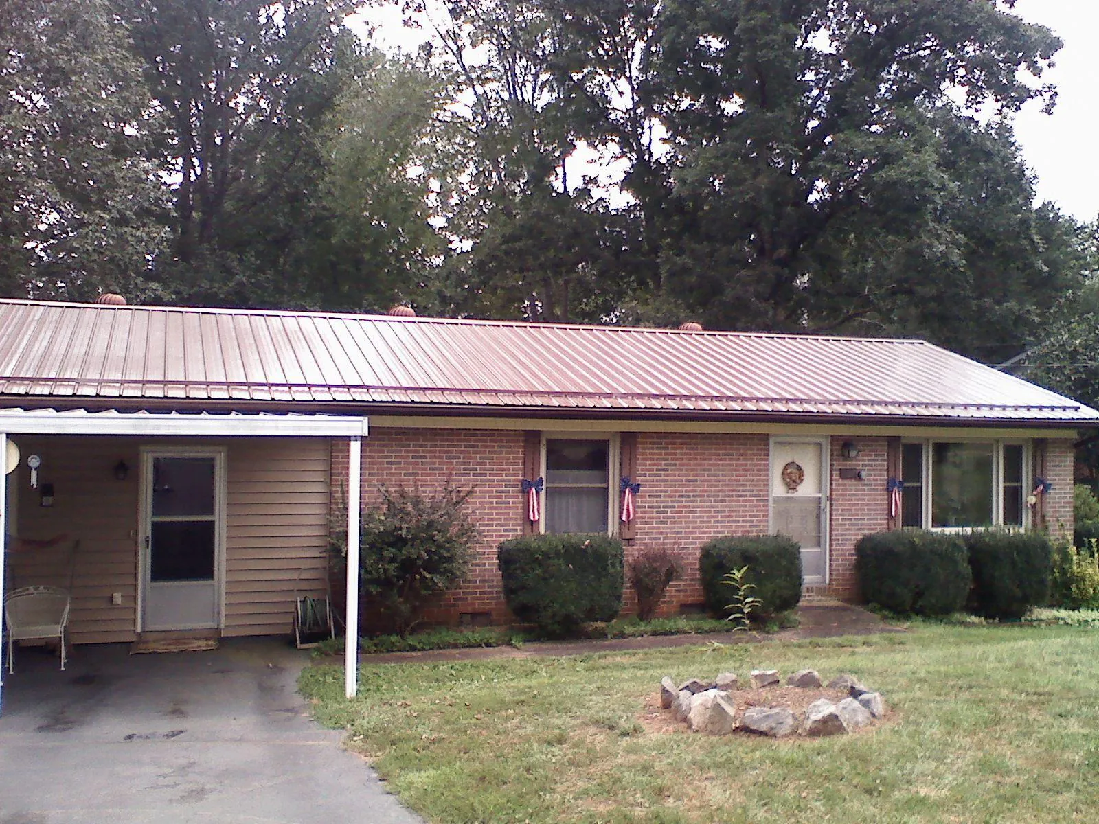 Bronze metal roof and carport on a brick ranch home — Roof Repair work by our crew in Port Tobacco