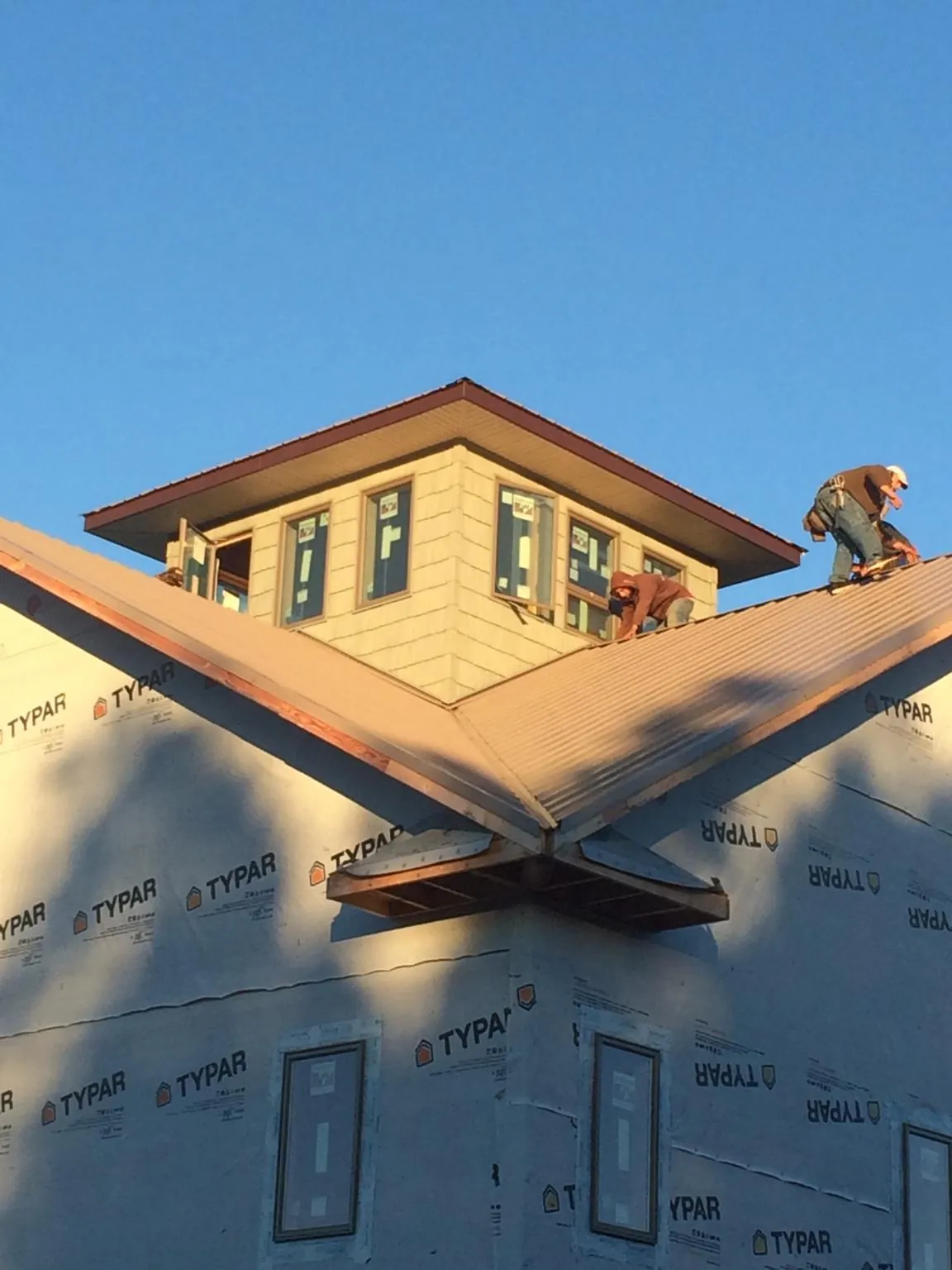 Roofers working around a rooftop cupola on a new metal roof at sunset — Roof Waterproofing in Port Tobacco by Roofing Brothers